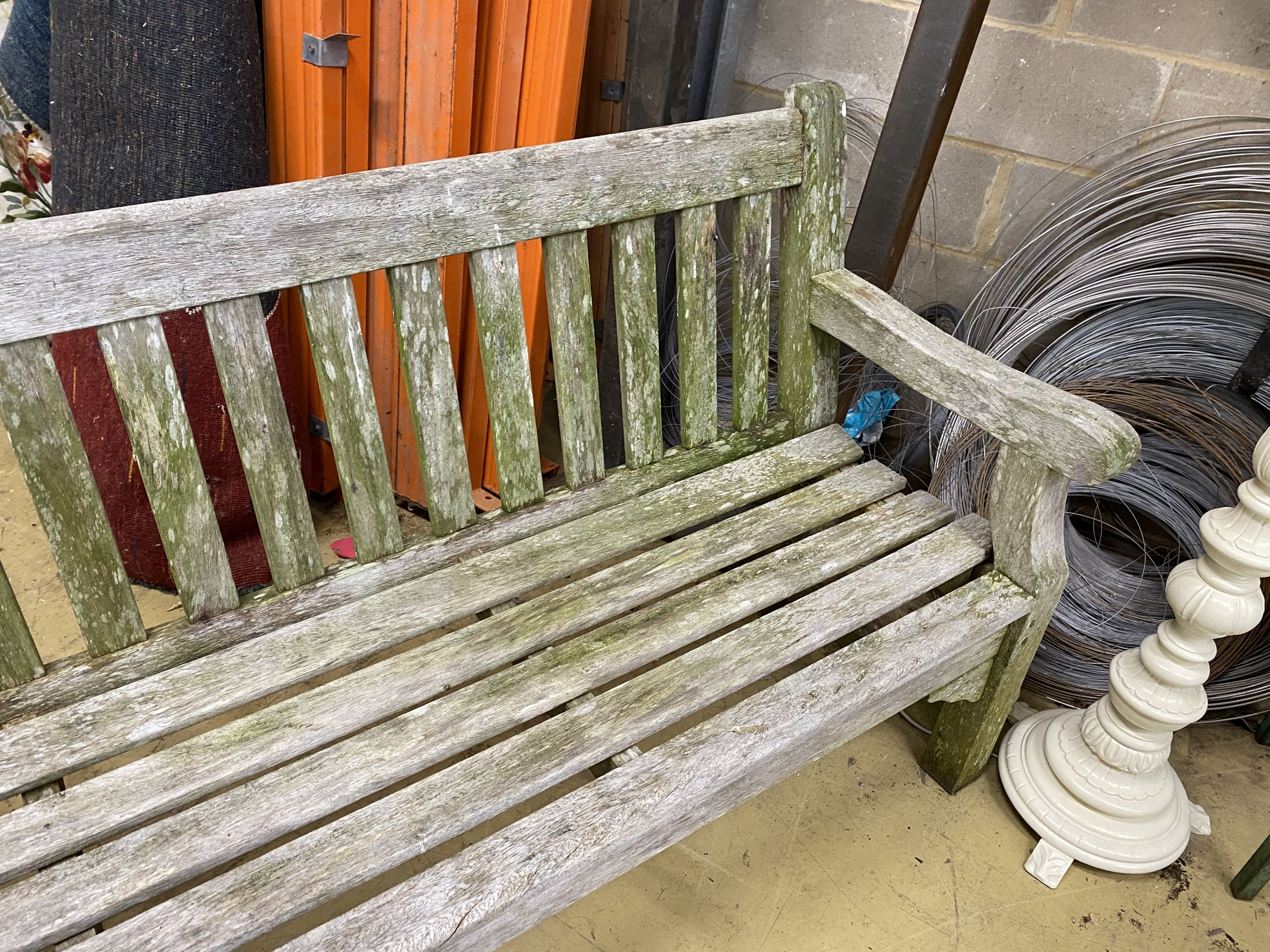 A weathered teak garden bench, length 182cm, depth 52cm, height 90cm